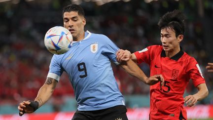 La star de l'Uruguay, Luis Suarez, au duel avec le défenseur sud-coréen, Moon-Hwan Kim, lors du match de Coupe du monde, le 24 novembre 2022, à Al Rayyan (Qatar). (EVRIM AYDIN / AFP)