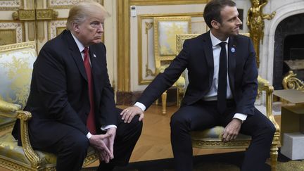 Emmanuel Macron pose une main sur un genou de Donald Trump, le 10 novembre 2018, à l'Elysée, à Paris. (SAUL LOEB / AFP)