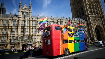 Un bus londonien aux couleurs LGBT passe devant le palais de Westminster, le 15 juillet 2013. (ANDREW COWIE / AFP)