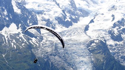 Un parapentiste descend devant le Monc-Blanc, le 1er juillet 2018 à Chamonix. (JEAN-PIERRE CLATOT / AFP)