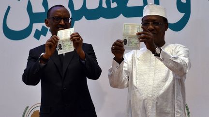 Les présidents du Rwanda, Paul Kagame (à gauche), et du Tchad, Idriss Deby, exhibent leur passeport panafricain à la tribune du 27ème sommet de l’Union africaine, le 17 juillet 2016, à Kigali, au Rwanda. (MINASSE WONDIMU HAILU / ANADOLU AGENCY)