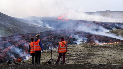 Sur place, des volcanologues de l'université d'Islande observent les coulées de lave lundi. (KRISTINN MAGNUSSON / AFP)