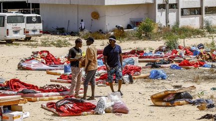 Des migrants à l'extérieur du centre de détention de Tajoura, dans la banlieue de Tripoli, le 3 juillet 2019. (MAHMUD TURKIA / AFP)