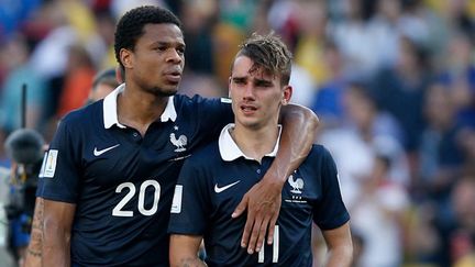 Antoine Griezmann inconsolable dans les bras de Loïc Rémy après l'élimination. (ADRIAN DENNIS / AFP)