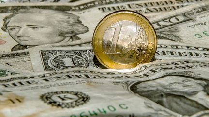 Une pièce d'un euro sur une pile de dollars. Photo prise le 13 mars 2015 à Godewaersvelde (France).  (AFP PHOTO / PHILIPPE HUGUEN)