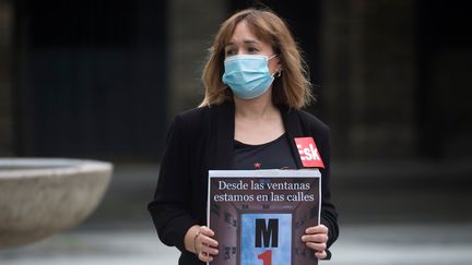 "Nous sommes dans la rue depuis nos fenêtres", dit la pancarte de cette membre d'un syndicat basque qui, elle, est descendue sur une place de Pampelune (Espagne). (ANDER GILLENEA / AFP)