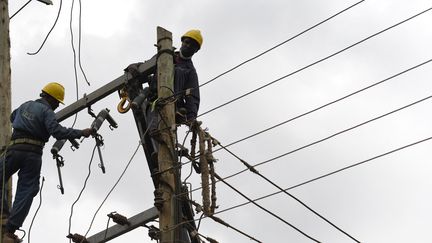 Des employés de l'entreprise publique Kenya Power démantèlent des câbles électriques lors de la construction de l'autoroute de Nairobi, à Westlands, le 24 septembre 2020. (SIMON MAINA / AFP)