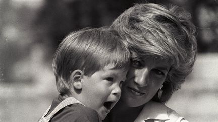 AOÛT 1988 - Le prince Harry dans les bras de sa mère, la princesse Diana, lors d’une séance photo matinale, au Marivent Palace (Espagne), où ils résident pour les vacances en tant qu’invités du roi et de la reine d’Espagne. (REUTERS)