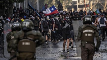 Des manifestants face à la police antiémeute, près du palais présidentiel à Santiago (Chili), le 29 octobre 2019.&nbsp; (PEDRO UGARTE / AFP)