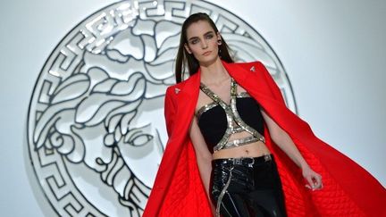 Chez Versace, la garde-robe est sous influence punk. Ces nouvelles "power women" sont perchées sur des bottines-stilettos hérissées de piquants ou des cuissardes en cuir, elles sont moulées dans des robes en vinyle noire, où de grands clous argentés font office d'épingles. En guise de bijoux, elles enserrent leur cou dans des colliers de chien aux longues pointes acérées et enfilent à leurs doigts des bagues hérisson. Le T-shirt noir punky fait bien partie de la garde-robe, tout comme la grosse chaîne qui se balance sur le flanc d'un pantalon moulant. Autre thème récurrent: le tartan, motif emblématique de ce mouvement contestataire. On le retrouve par touches ici et là. Des couleurs vives animent ce vestiaire à dominante sombre, tel ce manteau rouge vif ou cette fourrure de vison à zébrures teinte en jaune fluo. "Je propose un luxe irrévérent où le vinyle brillant se mélange à la soie, le cachemire à la fourrure", résume Donatella Versace .
 (G.Bouys / AFP)