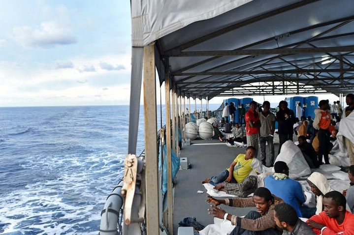 Des migrants et réfugiés africains, dont beaucoup de Sénégalais, après avoir été secourus en mer, se reposent sur le navire de la marine allemande Werra, le 27&nbsp;septembre 2015.  (ALBERTO PIZZOLI/AFP)