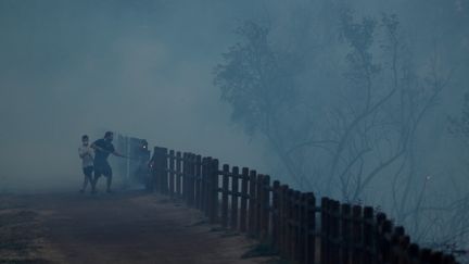 Les habitants tentent de faire un pare-feu le long d'une clôture de parc à Orange, en Californie, le 9 octobre 2017.&nbsp;&nbsp; (MIKE BLAKE / X00030)