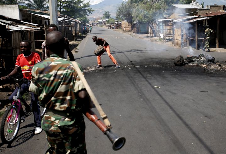 Un homme d&eacute;gage une barricade alors que des soldas patrouillent dans les rues de Bujumbura (Burundi), le 15 mai 2015. (GORAN TOMASEVIC / REUTERS )