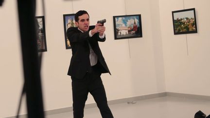 Le tireur d'Ankara qui a assassiné l'ambassadeur russe en Turquie gesticule après lui avoir tiré dessus pendant&nbsp;son discours d'inauguration d'une galerie d'art, le lundi 19 décembre. (BURHAN OZBILICI/AP/SIPA / AP)