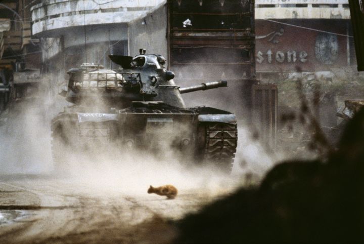 Liban, 1984. Beyrouth. Un char de l’armée libanaise chrétienne tire sur les milices musulmanes dans le centre-ville. Un chat de religion indéterminée fuit les combats. (Patrick Chauvel)