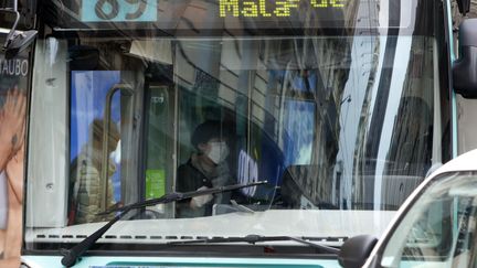 Une femme monte dans un bus, le 14 mars 2020 à Paris. (MEHDI TAAMALLAH / NURPHOTO / AFP)