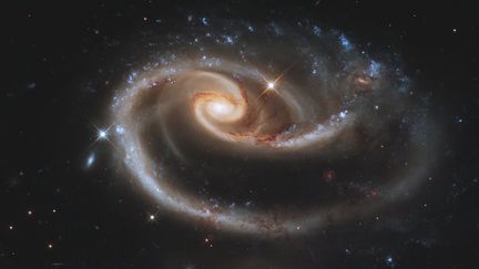 Parfois, les galaxies s'effleurent et interagissent. Cette paire, appelée Arp 273, se trouve à environ 300 millions années-lumières de nous, dans la&nbsp;constellation d'Andromède. La plus grande des deux s'appelle&nbsp;UGC 1810. Sa compagne : UGC 1813. (HUBBLE SPACE TELESCOPE / NASA / ESA)