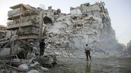 Les casques blancs,&nbsp;membres de la défense civile syrienne, tentent de sauver des victimes dans les décombres de bombardements à Alep en Syrie, en novembre 2016. (KARAM AL-MASRI / AFP)