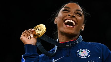 La gymnaste américaine Simone Biles, sur la plus haute marche du podium avec sa 3e médaille d'or pour le saut, le 3 août 2024 au JO de Paris, après celles du concours général par équipes et individuel. (PAUL ELLIS / AFP)