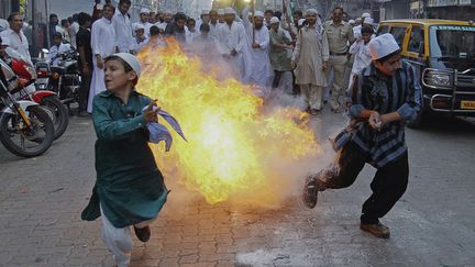 Des enfants s'enfuient apr&egrave;s l'explosion d'une p&eacute;tard lors de c&eacute;l&eacute;brations de la naissance du proph&egrave;te Mahomet &agrave; Bombay (Inde), le 5 f&eacute;vrier 2012. (DANISH SIDDIQUI / REUTERS)