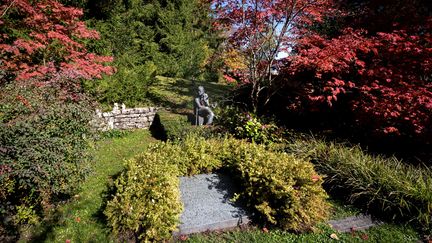 La tombe de James Joyce, et derrière la sépulture, une statue représentant l'écrivain irlandais, dans le cimetière Fluntern de Zurich (17 octobre 2019) (FABRICE COFFRINI / AFP)