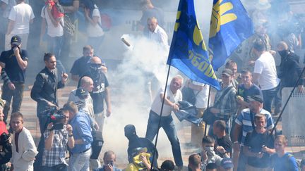 Certains manifestants brandissent le drapeau du parti d'extr&ecirc;me droite Svoboda devant le Parlement de Kiev, en Ukraine, o&ugrave; ont lieu des heurts, le 31 ao&ucirc;t 2015. (STRINGER / RIA NOVOSTI / AFP)