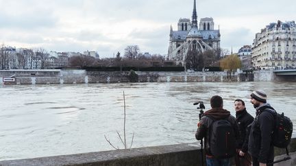 Des photographes observent le niveau de la Seine,&nbsp;dans le centre de Paris, le 27 janvier 2018. (DENIS MEYER / HANS LUCAS / AFP)