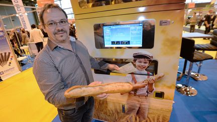 Jean-Louis Hecht pose pr&egrave;s de l'invention qui lui a permis de remporter le Concours L&eacute;pine 2014 : un automate qui&nbsp;cuit et vend du pain&nbsp;24 heures sur 24 et sept jours sur sept, &agrave; Paris, le 10 mai 2014. (PIERRE ANDRIEU / AFP)