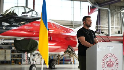 Le président ukrainien, Volodymyr Zelensky, s'exprime le 20 août 2023 à Skrydstrup (Danemark) devant un avion F-16 que Copenhague s'est engagée à céder à Kiev. (MADS CLAUS RASMUSSEN / RITZAU SCANPIX / AFP)