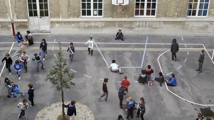 Des enfants jouent dans une cour de récréation à Paris, en octobre 2013. (THOMAS SAMSON / AFP)