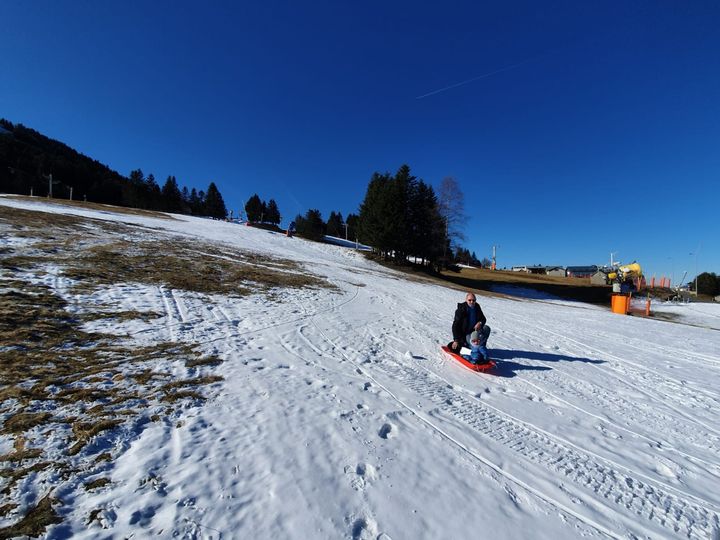 Didier, originaire de Lacanau et propriétaire d'une résidence secondaire au Mourtis, avec son petit fils sur leur luge. (LAURIANE DELANOE / RADIO FRANCE)