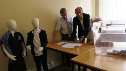 &nbsp;Le maire LR de Provins (Seine-et-Marne), Olivier Lavenka (au centre), signe le PV de la consultation pour le port de l'uniforme. (MAXPPP)