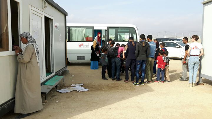 Les enfants attendent leur tour au pied du bus transformé par Médecins Sans Frontières en cabinet de psychologues dans le camp de Dibaga, au sud de Mossoul. (MATHILDE LEMAIRE / RADIO FRANCE)