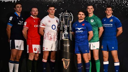 De droite à gauche Jamie Ritchie (Écosse), Ken Owens (pays de galles), Owen Farrell (Angleterre), Antoine Dupont (France), Jonathan Sexton (Irlande) et Michele Lamaro (Italie) les capitaines de leur sélection posent avec le trophée des Six Nations à Londres, le 23 janvier 2023. (BEN STANSALL / AFP)