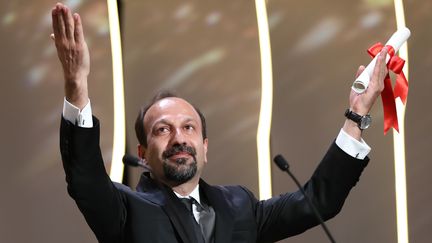 Le réalisateur iranien Asghar Farhadi recevant la palme du meilleur scénario, le 22 mai 2016, au Festival de Cannes, pour son film "Le Client". (VALERY HACHE / AFP)