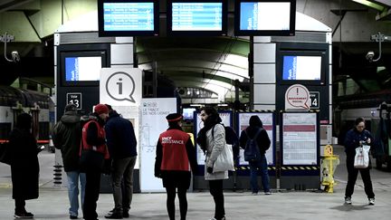 Des agents SNCF face à des voyageurs, en gare Montparnasse, à Paris, le 5 décembre 2019. (PHILIPPE LOPEZ / AFP)