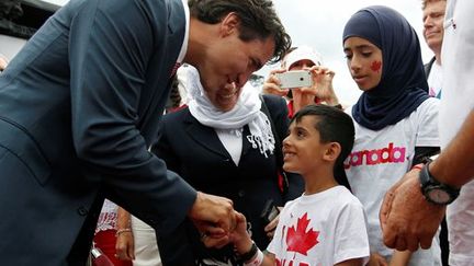 Justin Trudeau s'entretient avec des réfugiés syriens durant la fête nationale du Canada à Ottawa, le 1er juillet 2016. (REUTERS/Chris Wattie)