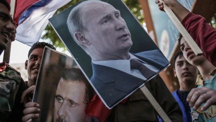 Manifestation en faveur du régime du président Assad dans la ville de Lattaquié, au nord de la Syrie. Lattaquié est la région natale de la famille Assad. Les manifestants brandissent des portraits du président syrien et du président Poutine, dernier soutien au régime. Le président russe a réussi à obliger les Américains à accepter une conférence internationale en présence des représentants du pouvoir syrien en place.  (ANDREY STENIN / RIA NOVOSTI)