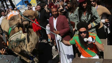 Tout aussi discret, Sasha&nbsp;"Le Dictateur" Baron Cohen a fait sensation devant l'h&ocirc;tel Carlton avec son dromadaire. (LOIC VENANCE / AFP)