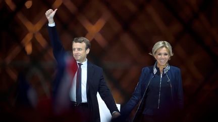 Emmanuel Macron, accompagné de son épouse Brigitte, célèbre sa victoire face à Marine Le Pen lors du second tour de l'élection présidentielle, le 7 mai 2017 devant la pyramide du Louvre, à Paris. (ERIC FEFERBERG / AFP)