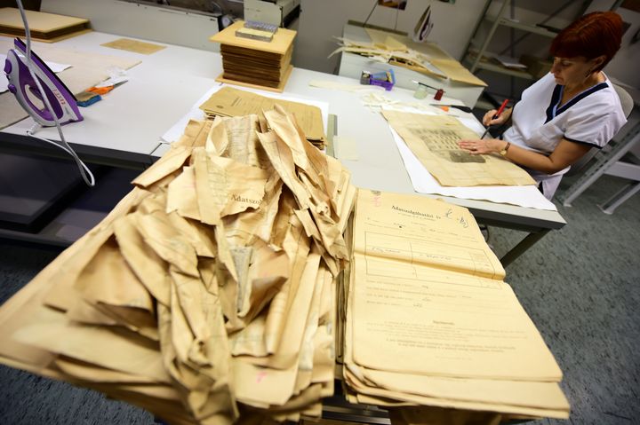 Monika Szabo, restauratrice des Archives municipales de Budapest (Hongrie), photographiée le 12 novembre 2015 alors qu'elle travaille sur un des 3 600 documents trouvés dans l'appartement du couple Berdefey. (ATTILA KISBENEDEK / AFP)