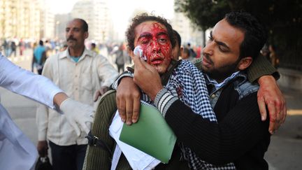 Des manifestants &eacute;vacuent un bless&eacute;, en marge des affrontements avec les forces &eacute;gyptiennes, le 17 d&eacute;cembre 2011 au Caire. (MOHAMED OMAR /&nbsp;EPA / MAXPPP)