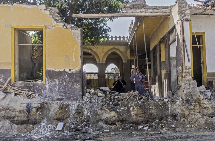 Des femmes résidant dans un cimetière en cours de démolition se tiennent dans les décombres engendrés par les travaux routiers en cours dans la nécropole historique de la Cité des morts au Caire, le 26 juillet 2020. (KHALED DESOUKI / AFP)