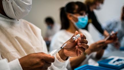 Des infirmières préparent des seringues du vaccin Pfizer-BioNtech au centre de vaccination de Paris La Défense Arena, le 8 mai 2021. (XOSE BOUZAS / HANS LUCAS / AFP)