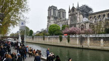 Des passants observent les dégâts occasionnés par l'incendie qui a ravagé la charpente de la cathédrale Notre-Dame de Paris. (DOMINIQUE BOUTIN / SPUTNIK / AFP)