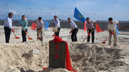 Cérémonie de pose de la première pierre pour la construction de deux phares sur le récif de Huayang (Cuarteron) en mer de Chine, en présence du ministre chinois des transports, le 26 mai 2015, pour sécuriser la navigation. (Lu Rui/XINHUA/AFP)