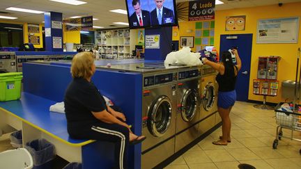 Retransmission du d&eacute;bat t&eacute;l&eacute;vis&eacute; entre Barack Obama et Mitt Romney dans une laverie automatique de Miami (Floride), le 3 octobre 2012. (JOE RAEDLE / GETTY IMAGES)