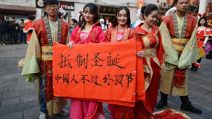 Des &eacute;tudiants chinois de la province du Wuhan brandissent une pancarte "R&eacute;sistez &agrave; No&euml;l :les Chinois ne devraient pas f&ecirc;ter ces &eacute;v&egrave;nements occidentaux", le 24 d&eacute;cembre 2014. (STR / AFP)