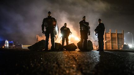 De gendarmes sécurisent les alentours après une intervention à la raffinerie de Donges, (Loire-Atlantique), bloquée par les grévistes qui protestent contre le passage en force de la réforme des retraites le 21 mars 2023. (LOIC VENANCE / AFP)