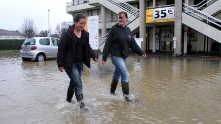 Deux jeunes femmes marchent dans une rue inond&eacute;e de Tarbes (Hautes-Pyr&eacute;n&eacute;es), le 25 janvier 2014. ( AFP )